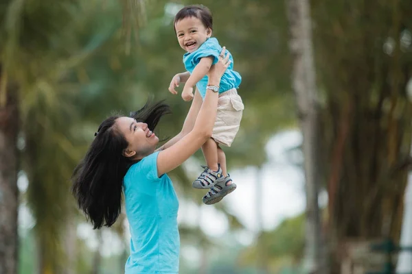 Madre llevando a su hijo — Foto de Stock