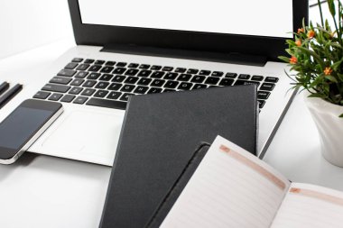 laptop ve defter çalışma yerinde