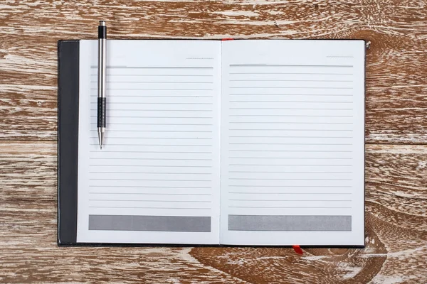 Notebook e caneta sobre fundo de madeira — Fotografia de Stock
