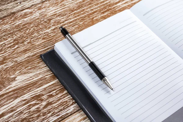 Notebook e penna su sfondo in legno — Foto Stock