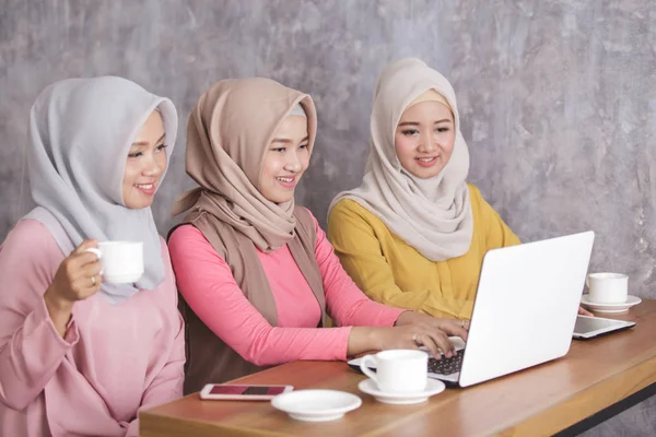 Tre bella donna musulmana lavorando sul loro computer portatile insieme a — Foto Stock