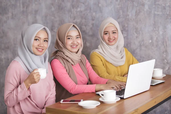 Tre bella donna musulmana lavorando sul loro computer portatile insieme a — Foto Stock