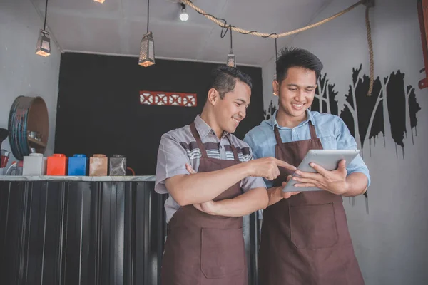 Coffee shop eigenaar bespreken met zijn werknemer met behulp van Tablet PC — Stockfoto