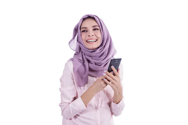 Bela mulher feliz vestindo hijab sorrindo enquanto segurando móvel — Fotografia de Stock