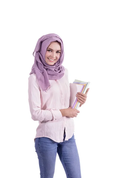 Hermosa estudiante universitaria con hijab sonriendo mientras que trae s —  Fotos de Stock