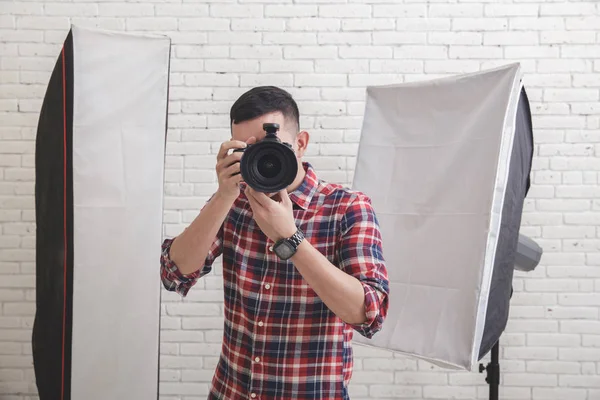 Young man taking photo with professional camera — Stock Photo, Image