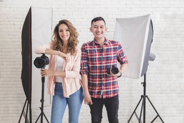 Två ung fotograf i studio med belysning i bakgrunden — Stockfoto