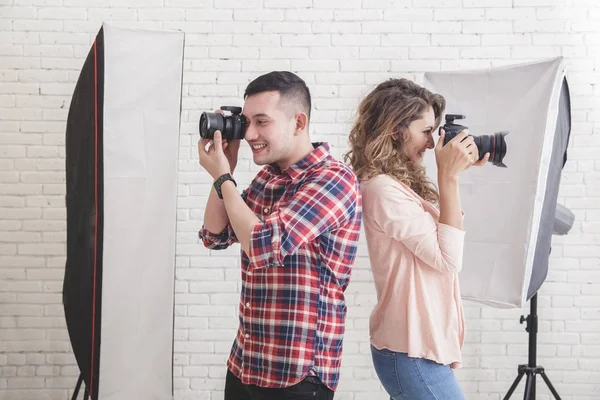 two young photographers back to back taking a photos