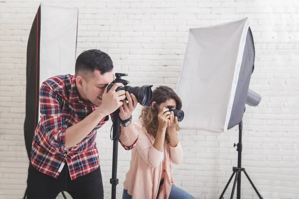 Dois jovens fotógrafos em ação tirando uma foto — Fotografia de Stock