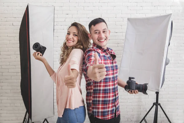 Twee jonge photogaphers geven duimen omhoog — Stockfoto