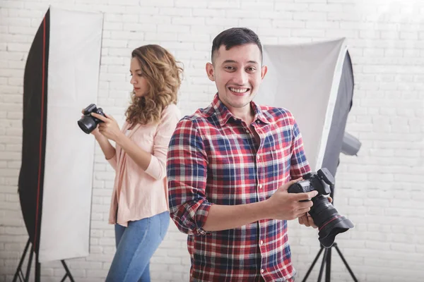 Young photographer smiling after having photo session while his — Stock Photo, Image