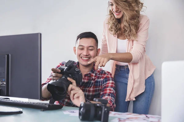 Joven fotógrafo compartir el resultado de la foto con su modelo — Foto de Stock