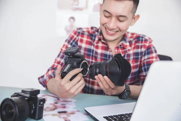 Молодий фотограф прикріплює об'єктив фотоапарата до тіла фотоапарата — стокове фото