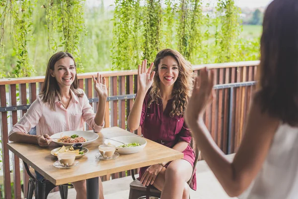 Twee vrouw die lacht terwijl handen zwaaien naar hun vrienden — Stockfoto