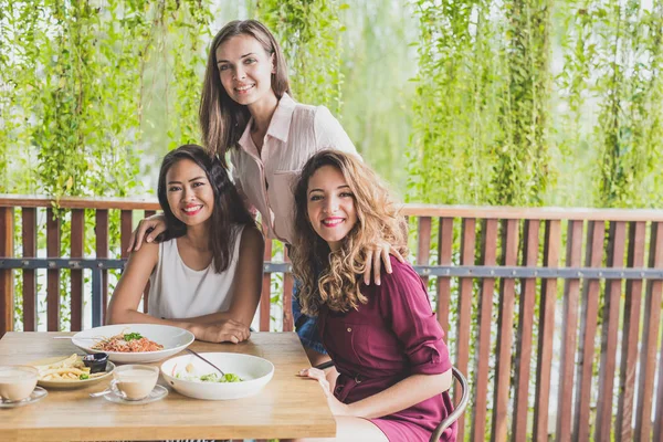 Счастливые трое лучших друзей обедают вместе в кафе — стоковое фото