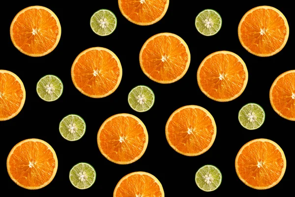 Padrão de frutas de laranja em fatias frescas e limão no fundo preto — Fotografia de Stock
