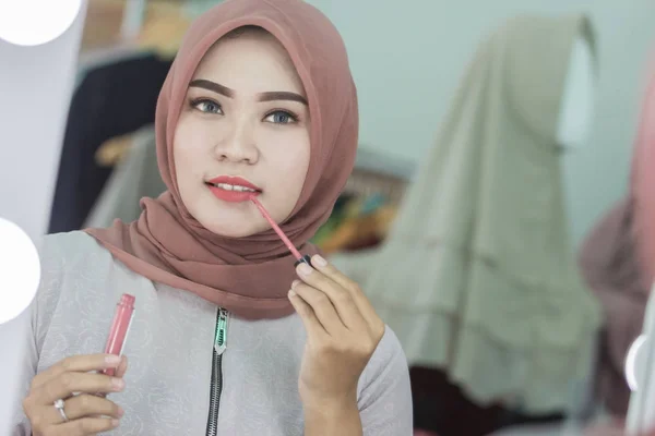 ヒジャーブの口紅を適用すると美しいアジアのイスラム教徒の女性 — ストック写真