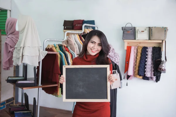 De eigenaar van de winkel van de mode met leeg bord — Stockfoto