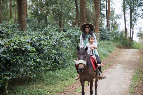 Bambino con mamma guida sulla cima del cavallo — Foto Stock