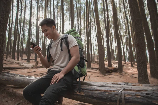 Caminhante masculino fazer uma pausa e usando o telefone móvel — Fotografia de Stock