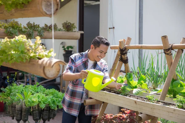 Glücklicher Mann, der seinen Garten wässert — Stockfoto