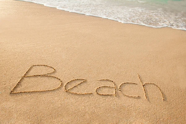 Palavra praia escrita na praia de areia — Fotografia de Stock