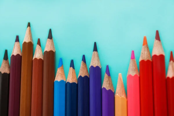 Pastel arka plan üzerinde renkli kalemler — Stok fotoğraf