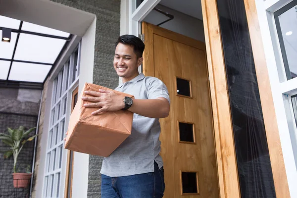 Uomo che riceve una scatola di consegna a casa — Foto Stock