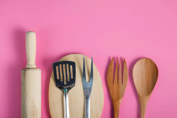 Olika köksredskap på rosa bakgrund — Stockfoto
