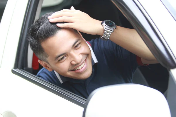 Mannen fastställande hans hår medan du sitter i en bil — Stockfoto