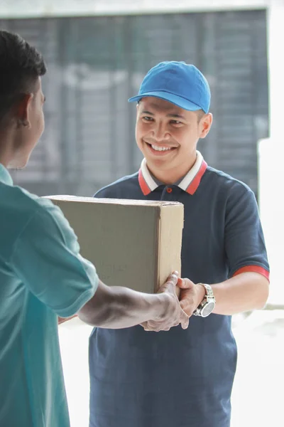 Hombre entrega feliz con paquete — Foto de Stock