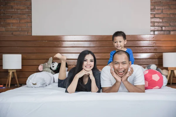 Yatakta mutlu Asya aile — Stok fotoğraf