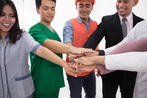 Diversas profesiones personas ponen las manos juntas —  Fotos de Stock