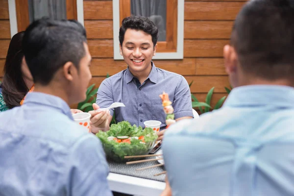 Amigos disfrutando de la comida en la fiesta al aire libre — Foto de Stock