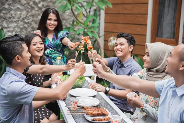 Friends enjoying meal at outdoor party — Stock fotografie