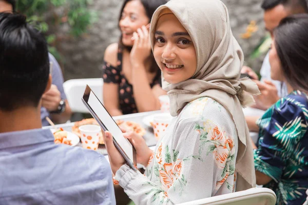 Muçulmano asiático mulher usando guia enquanto com amigos — Fotografia de Stock