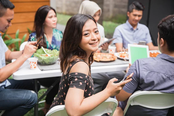 Mujer asiática usando tab mientras con amigos — Foto de Stock