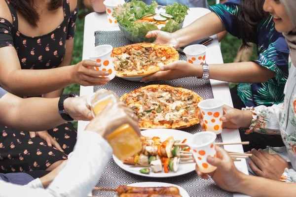 Amigos disfrutando de la comida en la fiesta al aire libre — Foto de Stock