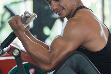 Adam pazılar için ağır ağırlık egzersizi yapıyor.