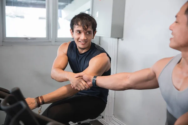 Asijské muži shakehand v tělocvičně dělat kardio cvičení — Stock fotografie