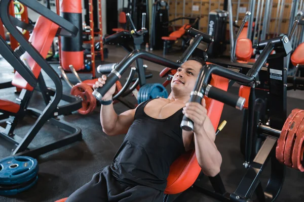 Handsome asian male doing chest exercises