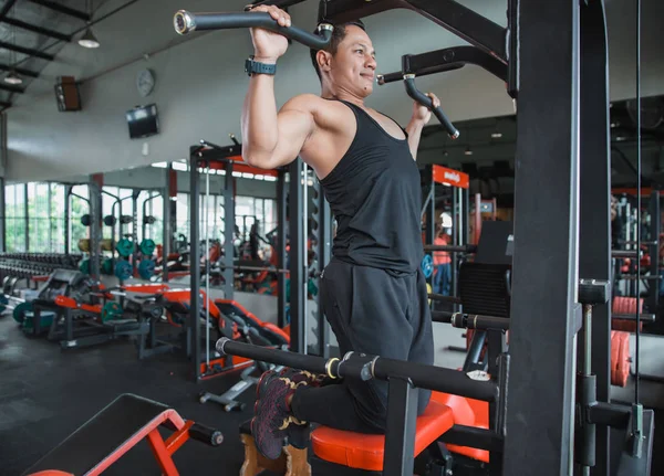 Aziatisch mens uit te oefenen en doen pull ups — Stockfoto