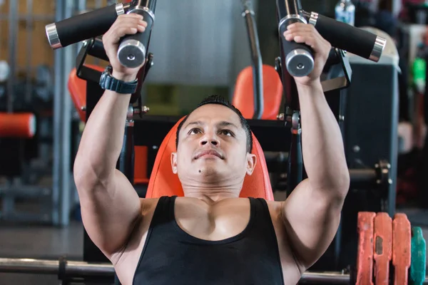 Handsome asian male doing chest exercises