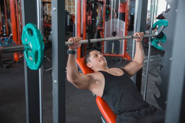 Kaslı vücut geliştirmeci sıra sıkıştırma egzersiz smith makine ile