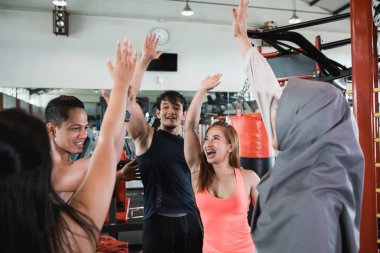 Grup insanlar ve kadın Tesettür spor salonunda çak bir beşlik yapma