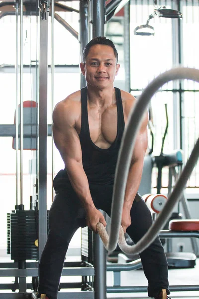 El hombre musculoso está haciendo ejercicio de cuerda de batalla —  Fotos de Stock