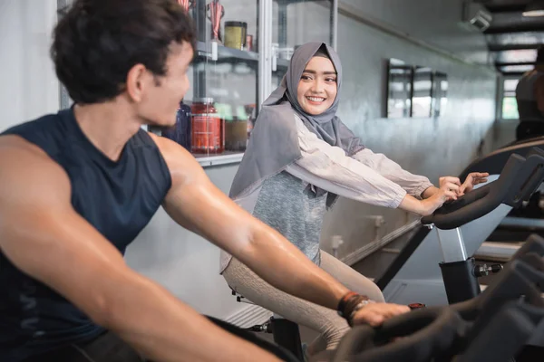 Muslim woman hijab and friend at the gym doing cardio exercises