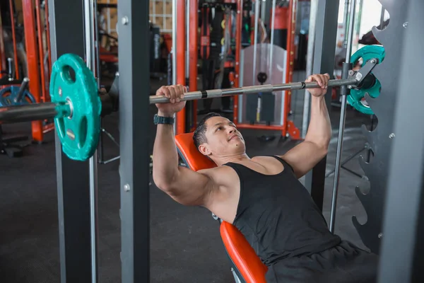 Bodybuilder muscolare panca stampa allenamento con macchina fabbro — Foto Stock