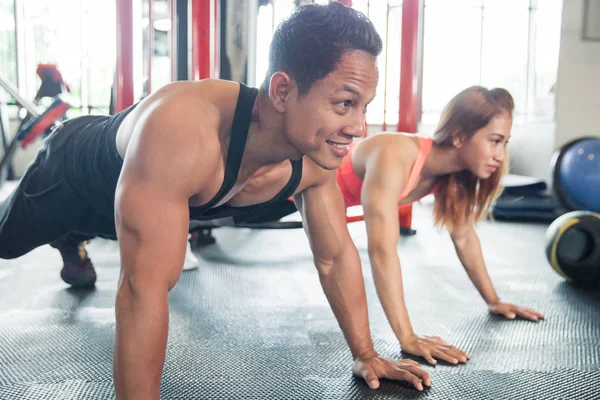 Man en vrouw doet push ups — Stockfoto