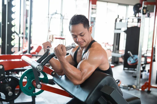 Entrenamiento muscular del hombre en la máquina de ejercicio — Foto de Stock